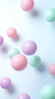 Pastel colored spheres floating on soft gradient background with pink purple and mint green balls creating dreamy abstract composition for modern design projects.