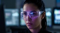 Young Hispanic woman scientist wearing protective eyewear in modern laboratory with digital screens background for research and technology concepts.