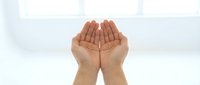 Open cupped hands gesture showing palms up in receiving position against clean white background for prayer, giving, charity and spiritual concepts.
