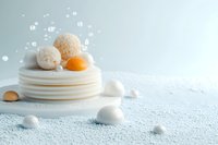 Artistic minimalist composition of stacked white pancakes with eggs, powdered sugar, and scattered pearls on a soft blue background.