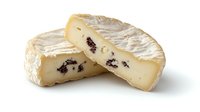Artisanal soft cheese wheel with cranberries cut in half showing creamy texture and dried fruit pieces isolated on white background for culinary design.