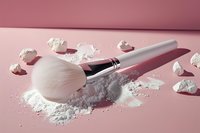 White fluffy makeup brush with loose face powder scattered on pink background, creating soft shadows and professional cosmetic composition.