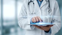 Medical professional using digital tablet with heartbeat pulse line overlay in modern healthcare setting for telemedicine and patient care.