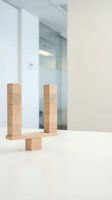 Wooden blocks arranged in balance configuration on white surface in modern minimalist office interior for business strategy and teamwork concepts.