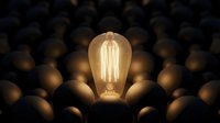 Vintage Edison bulb glowing brightly among dimmed bulbs, symbolizing innovation, leadership, and standing out from the crowd for business concepts.