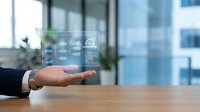 Businessman holding open palm with digital technology icons floating above hand in modern office environment for business solutions and innovation concepts.