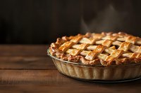 Freshly baked apple pie with golden lattice crust on rustic wooden table, steam rising from warm pastry in moody lighting, traditional homemade dessert.