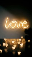Glowing neon love sign on dark wall with bokeh heart lights, warm golden ambiance for Valentine's day, wedding, or romantic decor.