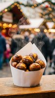 Steaming roasted chestnuts in paper cone at festive Christmas market with bokeh lights and holiday stalls in background.