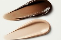 Smooth creamy foundation or concealer swatches showing different skin tone shades with glossy texture smeared on white background for makeup and cosmetics.