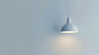 Minimalist pendant lamp illuminating empty wall with soft warm light creating atmospheric mood and clean modern interior design aesthetic.