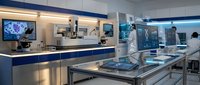 Modern laboratory interior with stainless steel equipment and blue accents. Scientists working in sterile research facility with advanced technology and clean workspace.
