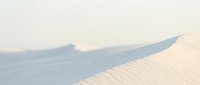 Soft pastel sand dunes with gentle curves and shadows creating minimalist desert landscape for peaceful meditation and wellness content.