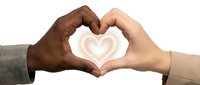 Two diverse hands forming heart shape symbol representing unity, love, friendship and racial harmony on white background.
