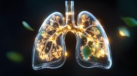 Glowing translucent human lungs with illuminated bronchial tree structure against dark background showing detailed respiratory system anatomy in golden light.