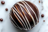 Dark chocolate truffle with white chocolate drizzle on marble surface, macro food photography showing rich texture and glossy finish. Perfect for confectionery marketing.