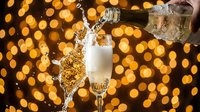 Champagne pouring into glass with golden bokeh lights in background, celebration and festive party drink for New Year's Eve, weddings, and special occasions.