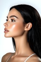 Side profile portrait of young Asian woman with glowing skin, long black hair, and natural makeup wearing white tank top against light background.
