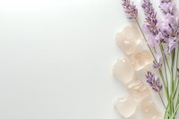 Fresh lavender sprigs with pink himalayan salt crystals arranged on white background, creating minimalist spa and wellness composition. Copy space.