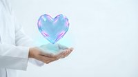 Healthcare professional holding glowing holographic heart symbol representing medical care, cardiology treatment and wellness technology in modern medicine.