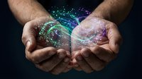 Male hands holding glowing digital sphere with colorful particles and light effects representing technology, innovation, and futuristic concepts for business.