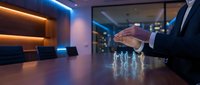 Businessman hand protecting glowing human figures on conference table in modern office boardroom representing team leadership and employee protection concept.
