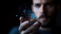 Young businessman holding glowing digital particles and light effects in cupped hands against dark background for technology and innovation concepts.