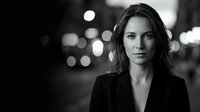 Professional businesswoman portrait in black and white with city lights bokeh background for corporate branding and marketing materials.