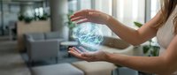 Young businesswoman holding glowing digital globe hologram between hands in modern office environment showcasing global connectivity and technology.