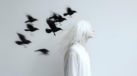 Young woman with long white hair in profile against light background with black flying birds creating dramatic silhouettes and ethereal atmosphere.
