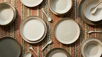 Overhead view of cream and white ceramic bowls with spoons arranged on woven jute texture, perfect for food styling, recipe blogs, cooking content, and tableware design projects.