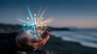 Weathered hand holding glowing compass rose with cardinal directions against twilight ocean backdrop and starry sky, symbolizing navigation, guidance, and direction-finding for travel and adventure concepts.