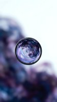 Cosmic galaxy sphere floating with purple and blue nebula colors against blurred background for creative design projects.