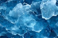 Frozen blue ice chunks with air bubbles trapped inside create abstract winter texture pattern. Natural crystalline surface in cold environment.
