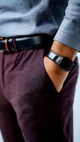 Close-up of African American man's wrist wearing smart fitness tracker, blue checkered shirt and burgundy dotted pants, showcasing modern business casual style.