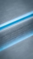Close-up of metallic surface with bright blue glowing stripes creating modern, tech-inspired abstract pattern. Suitable for technology, innovation, and corporate design projects.