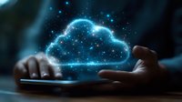 Glowing blue cloud computing concept with hands typing on laptop keyboard in dark room, digital technology and network connection visualization.
