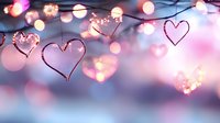 Glowing heart shapes and bokeh lights create romantic atmosphere against blurred pink and blue background, festive holiday decoration for Valentine's Day celebration.