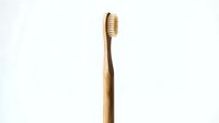 Eco-friendly bamboo toothbrush with natural bristles isolated on white background for sustainable dental care and zero waste lifestyle products.
