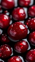 Fresh ripe cherries with water drops in macro shot on dark background, showing glossy red surface and natural texture for food photography and design.