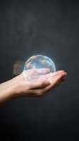 Hand holding glowing digital earth globe with network connections floating above palm against dark background for technology and global concepts.
