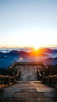 Stone terrace with ornate railings overlooks misty mountain landscape during golden sunrise, ideal for travel and nature themes.