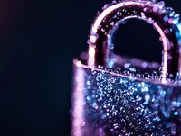 Glittering padlock with purple and blue bokeh lights on dark background creates magical atmosphere for security and protection concepts.