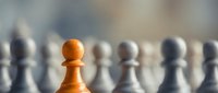 Orange chess pawn standing out among white pieces on board, symbolizing leadership, uniqueness and strategic thinking in business concepts.