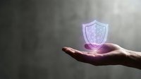 Hand holding glowing holographic shield symbol representing cybersecurity, data protection and digital safety concepts for business presentations.