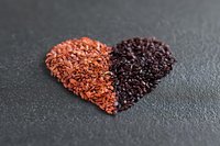 Heart shape made from contrasting red and dark chocolate shavings arranged on dark slate background, symbolizing love and culinary creativity.