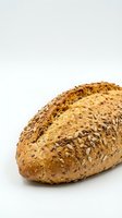 Fresh baked multigrain bread loaf with seeds isolated on white background for bakery and healthy eating concepts.