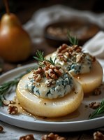 Poached pears with blue cheese, walnuts and rosemary on white plate. Gourmet dessert or appetizer for fine dining, holiday entertaining and culinary blogs.