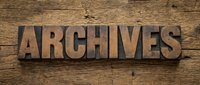 Vintage wooden letterpress blocks spelling ARCHIVES on rustic wood background for historical documentation and record keeping projects.