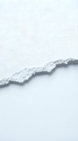 Torn white paper edge with ragged texture on light gray background, suitable for design overlays, web graphics, and creative layouts.